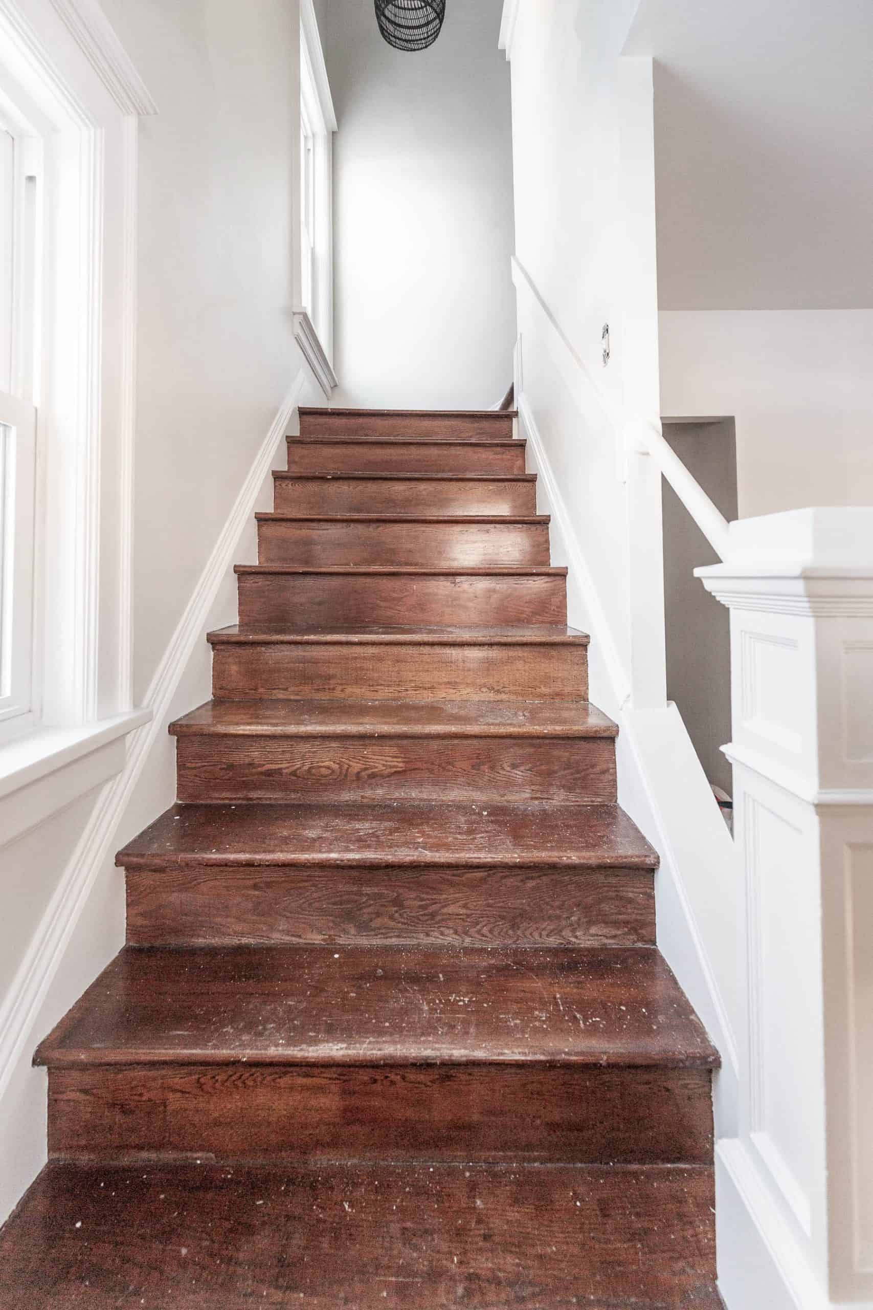 Wooden staircase with white walls and railing, interior home decor.