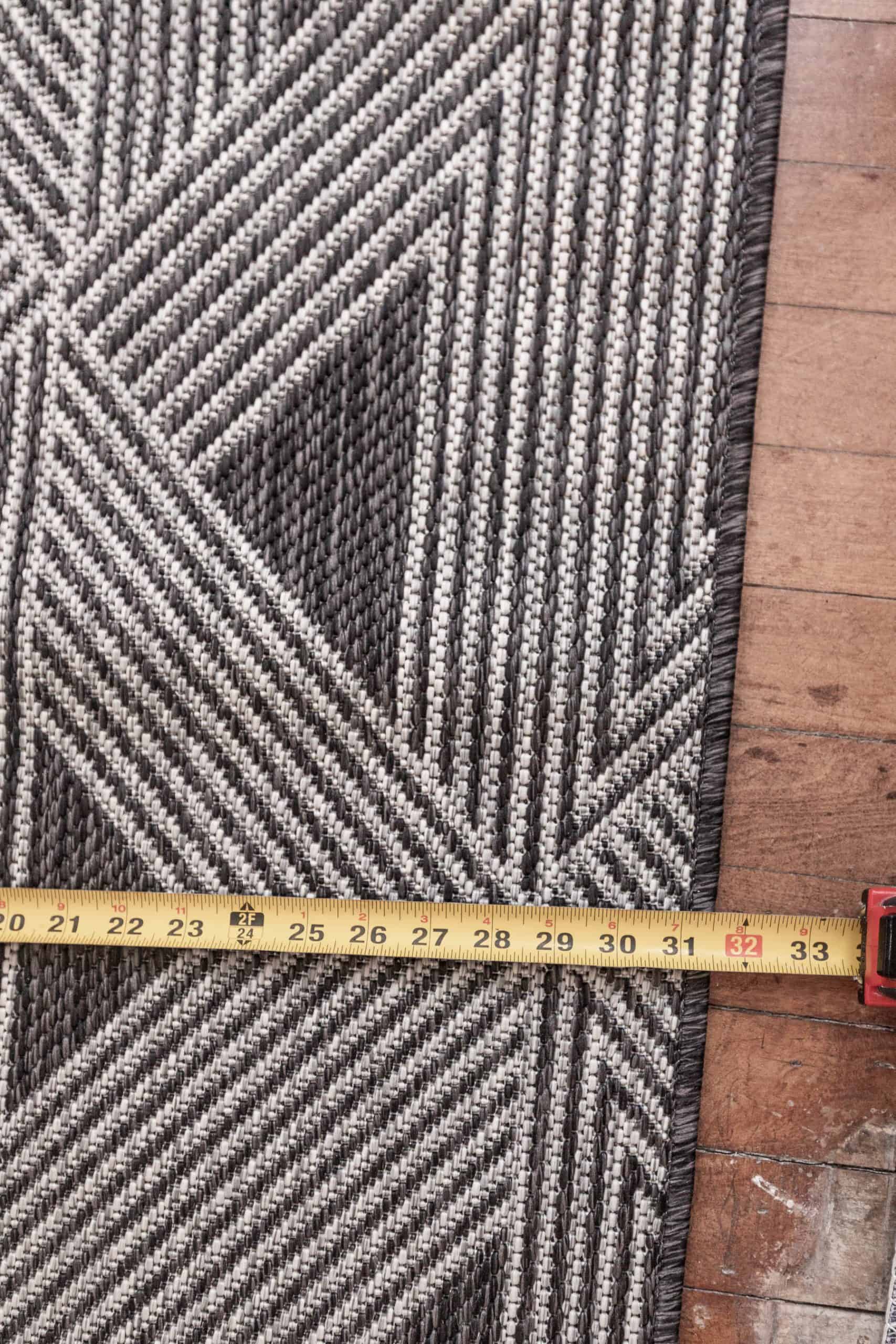 Close-up of a geometric stair runner with measuring tape.