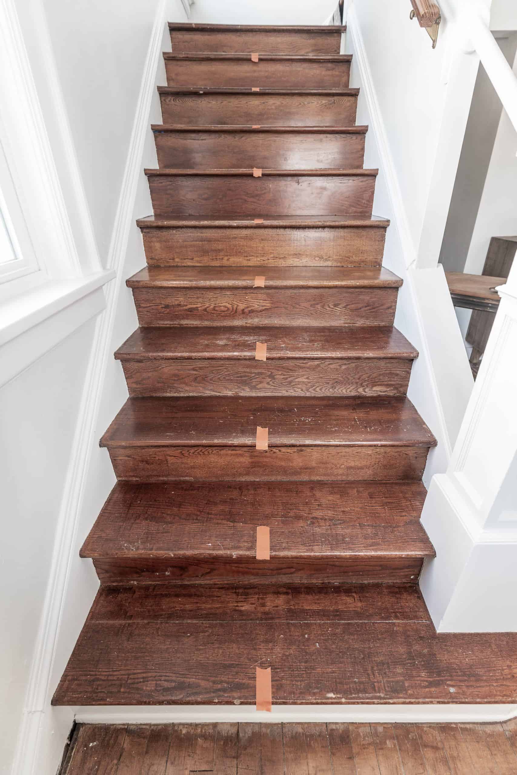 Wooden staircase with stair runner installation in a home interior.