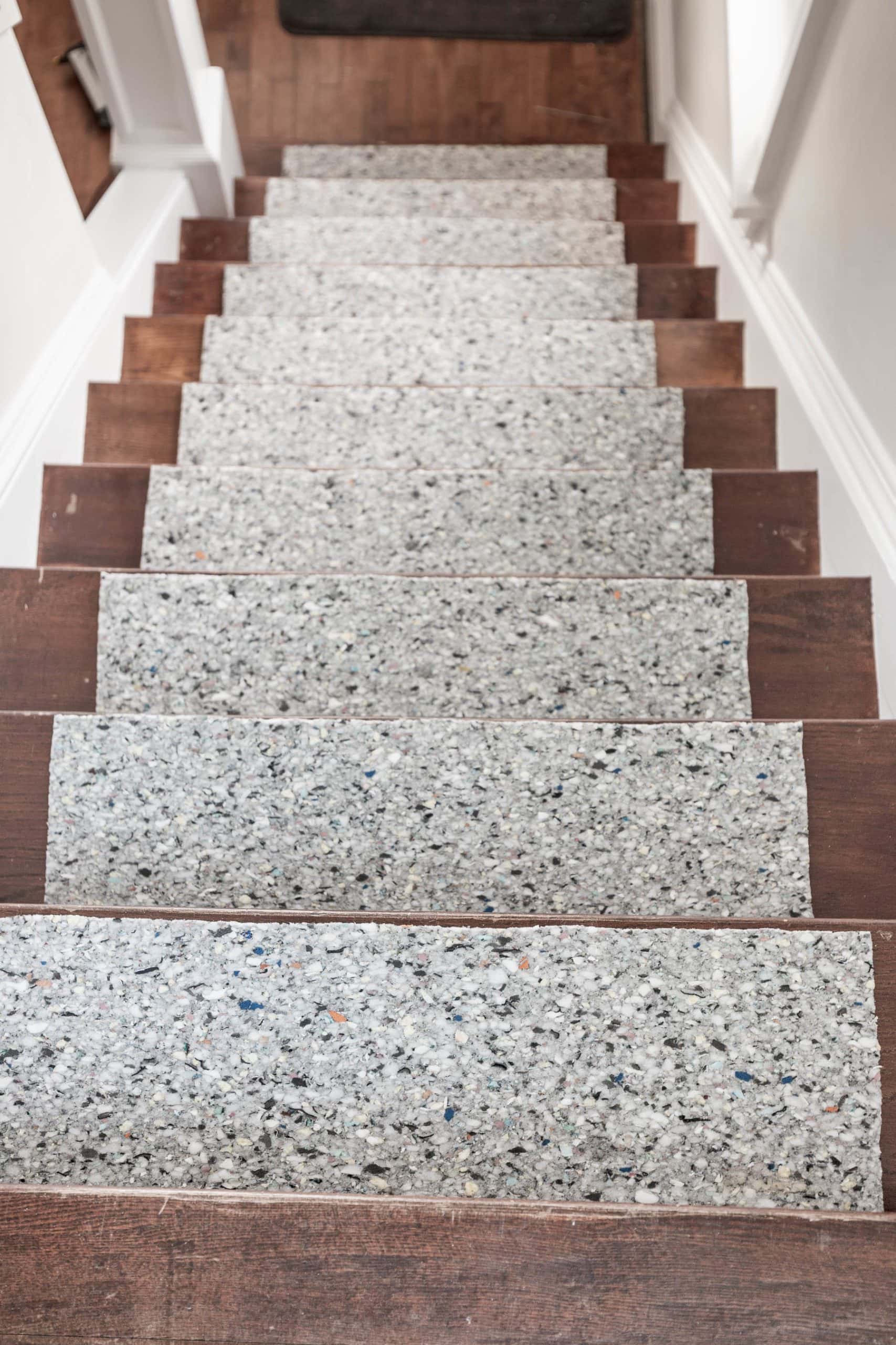 Staircase with granite stair runner and wooden edges.
