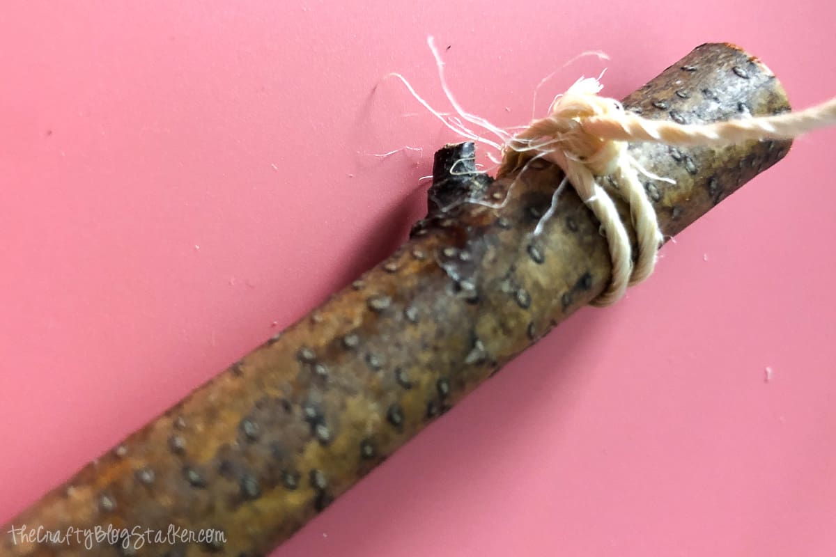 The end of a stick with with twine wrapped around it and tied tight.