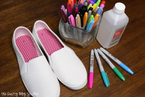 white slip-on shoes, sharpie markers and isopropyl alcohol