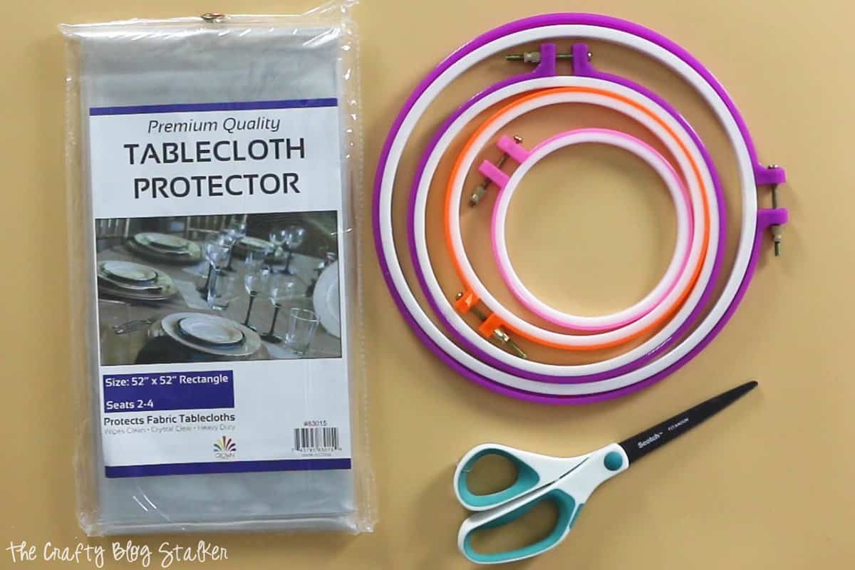 embroidery hoops, scissors, and tablecloth protector