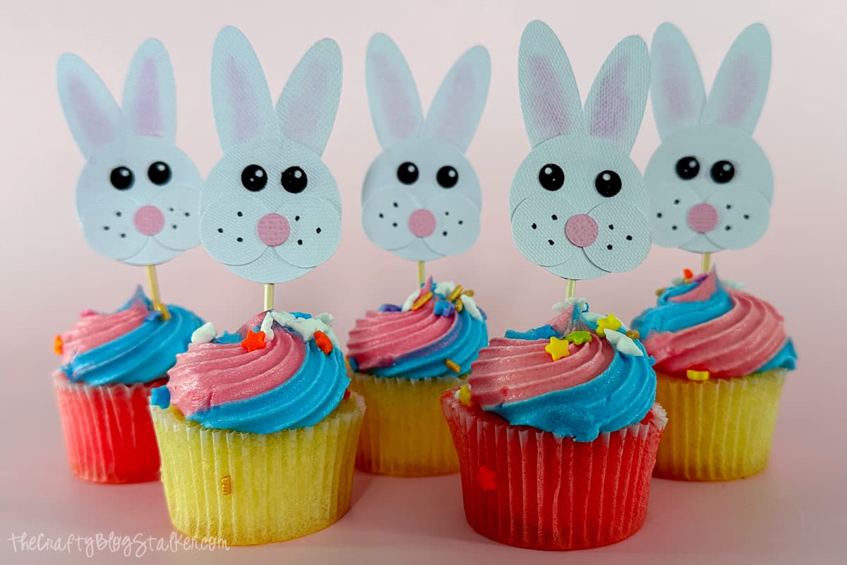 Five mini cupcakes with bunny cupcake toppers.