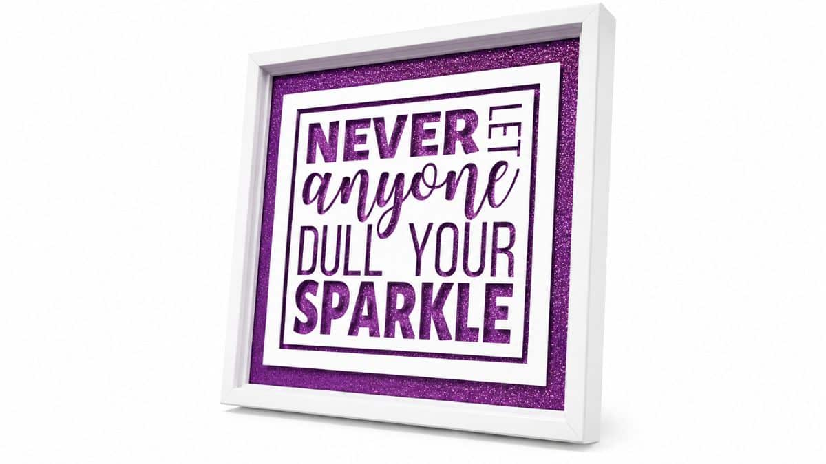 Finished white shadow box frame with a purple glitter background and layered vinyl quote that reads