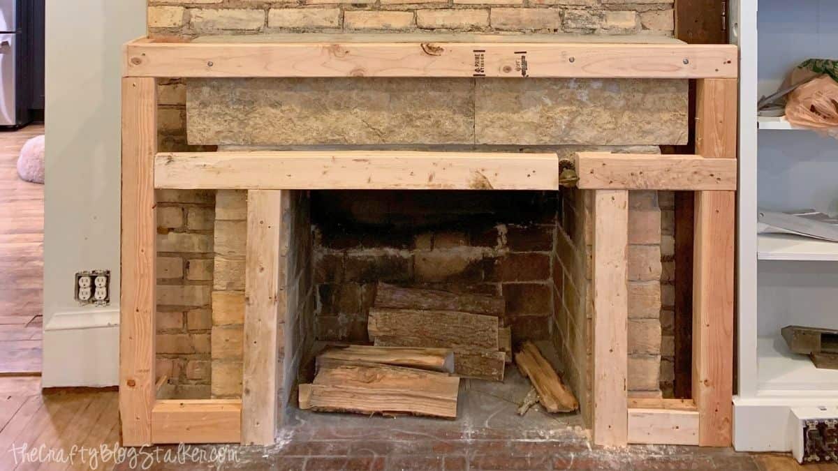 Wood framing installed around a brick fireplace to prepare for a concrete fireplace makeover before applying the finish.