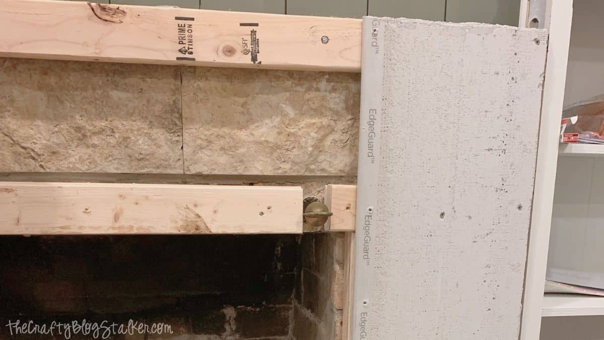 Cement backer board installed over a fireplace surround, preparing the surface for a DIY concrete fireplace finish.