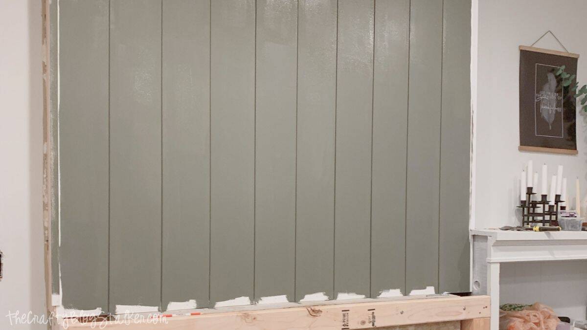 Painted vertical shiplap installed above a fireplace, creating a clean accent wall during a DIY fireplace makeover renovation.