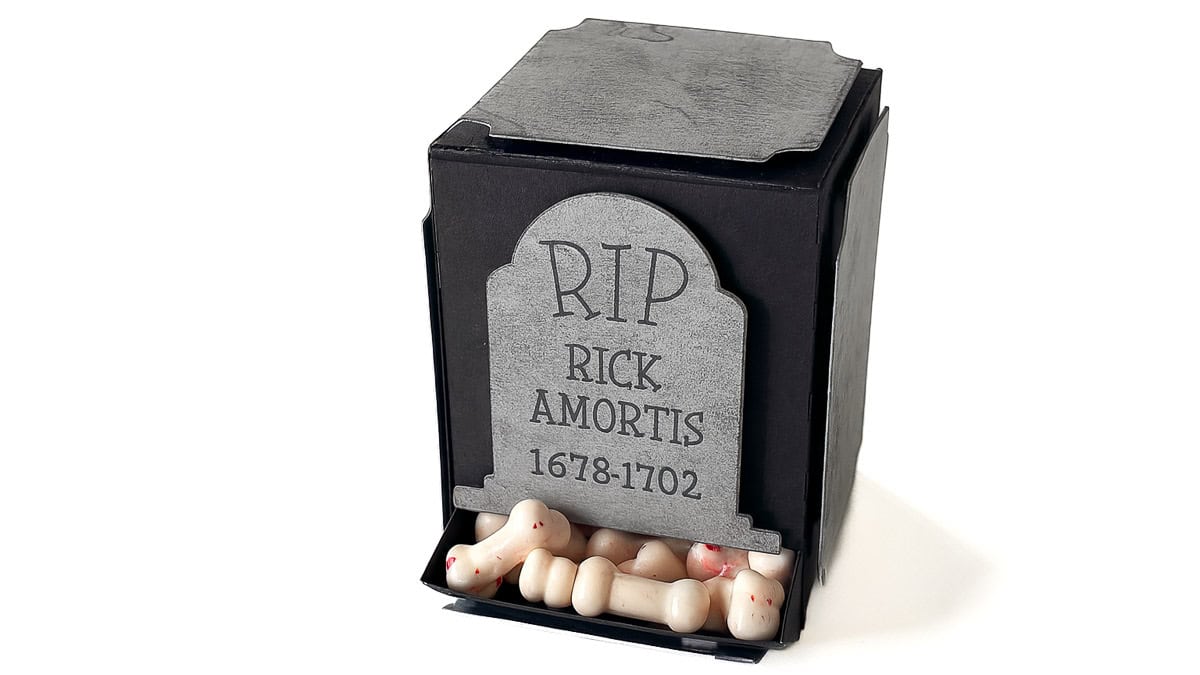 Black paper gravestone-shaped candy box labeled