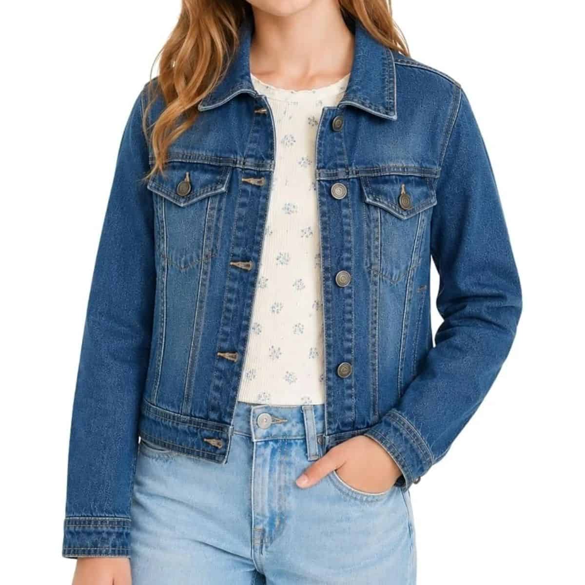 Blue denim jacket with button-front closure, chest flap pockets, and a pointed collar, styled with a floral top and light-wash jeans.