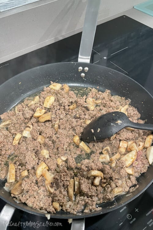 browned ground beef mixture in a skillet on the stove