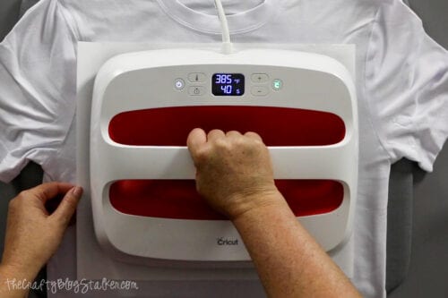 applying heat and pressure to a shirt using a cricut easypress