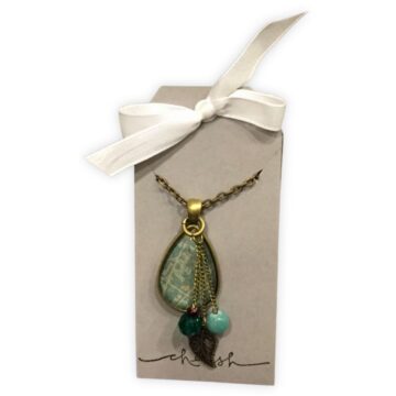 Handmade teardrop pendant necklace with charms and beads, displayed on a custom card with a white ribbon bow and "cherish" stamped at the bottom.