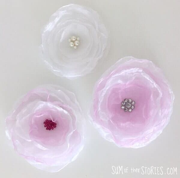 3 organza flowers that are pink and white.