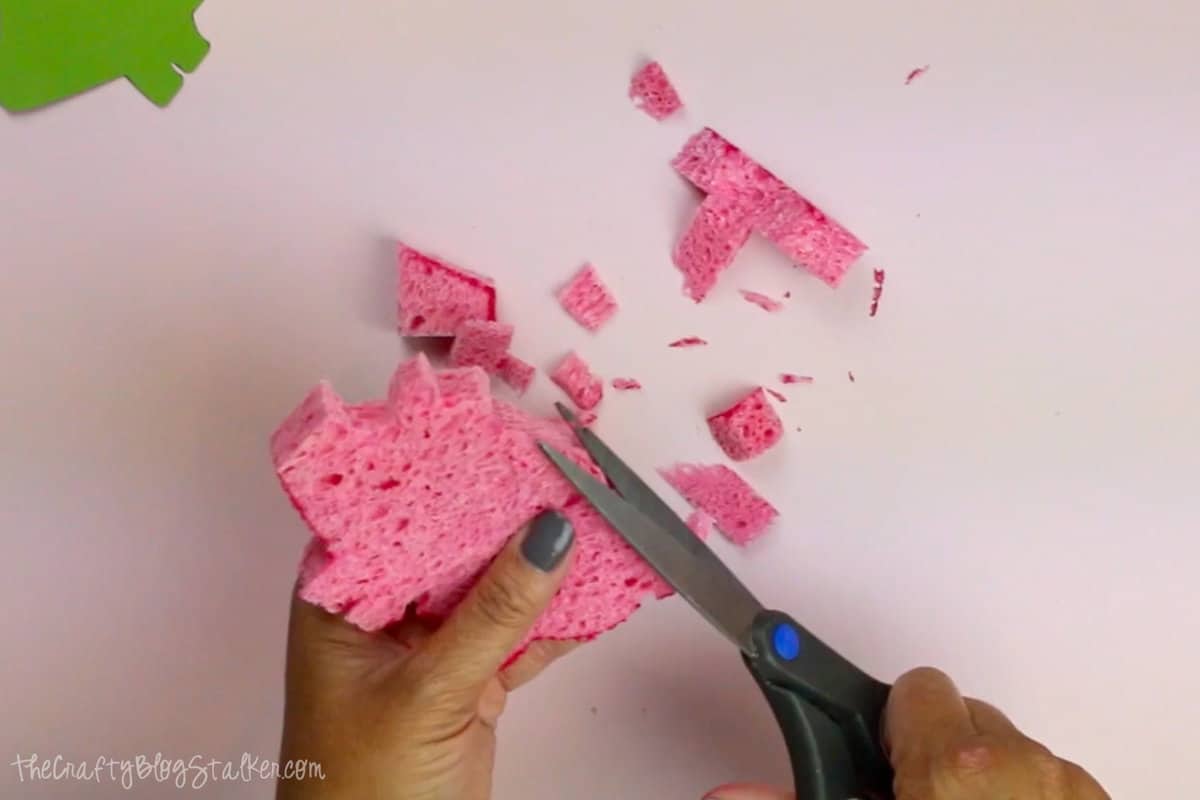 Hands trimming the pig shaped sponge.