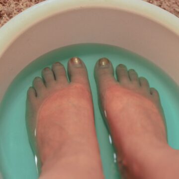 Feet soaking in a blue liquid.