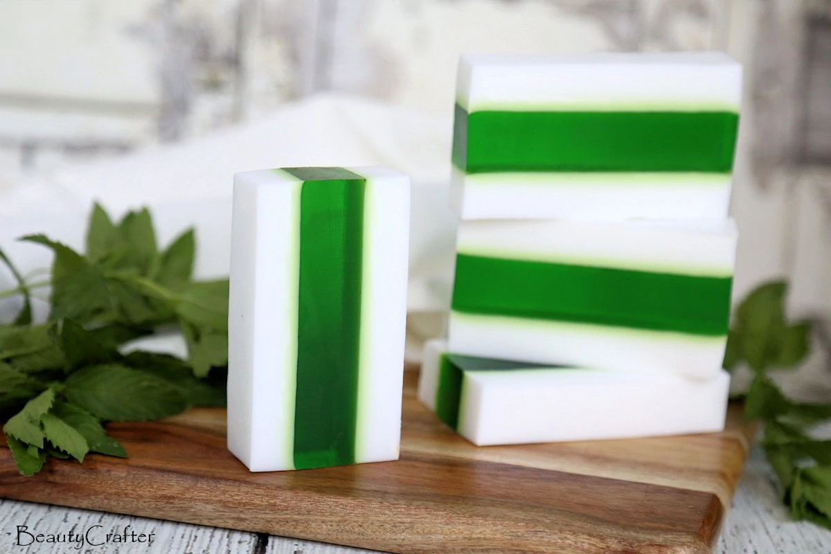 Striped green and white soap bars on a wood cutting board.