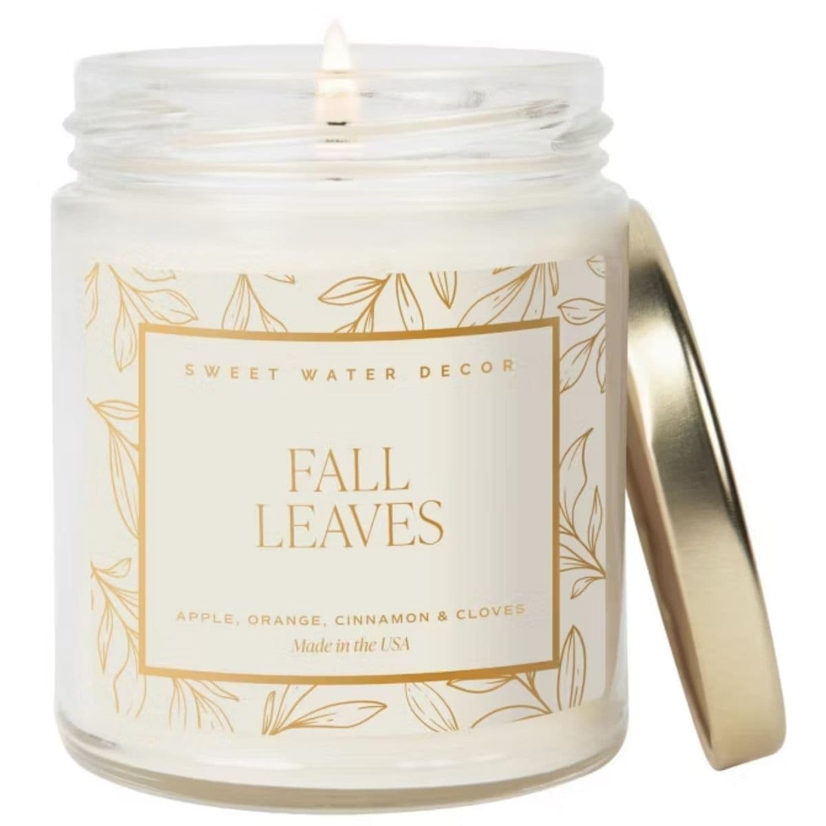 Lit Fall Leaves scented candle in a glass jar with a gold lid, featuring apple, orange, cinnamon, and clove fragrance.