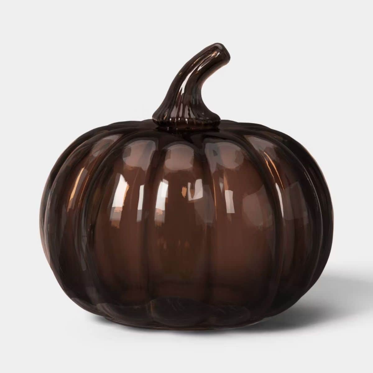 Dark brown glass pumpkin with a glossy translucent finish, ribbed shape, and curved stem on a white background.