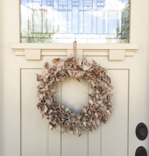 Fabric Wreath hanging on a white front door.