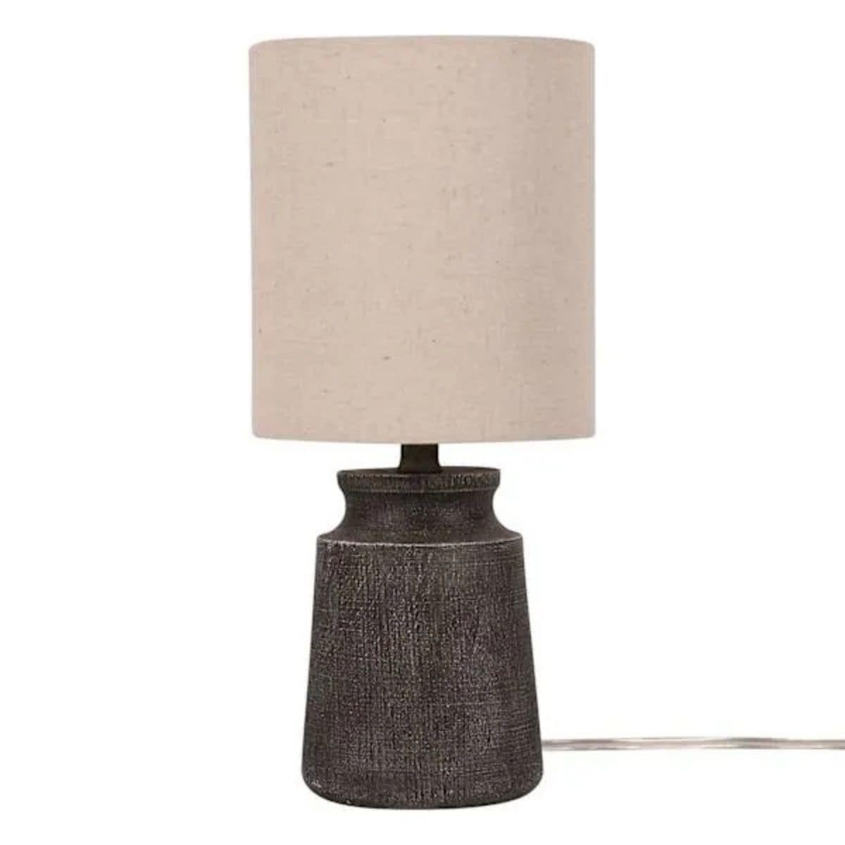 Mini table lamp with a textured dark base and simple beige fabric drum shade on a white background.