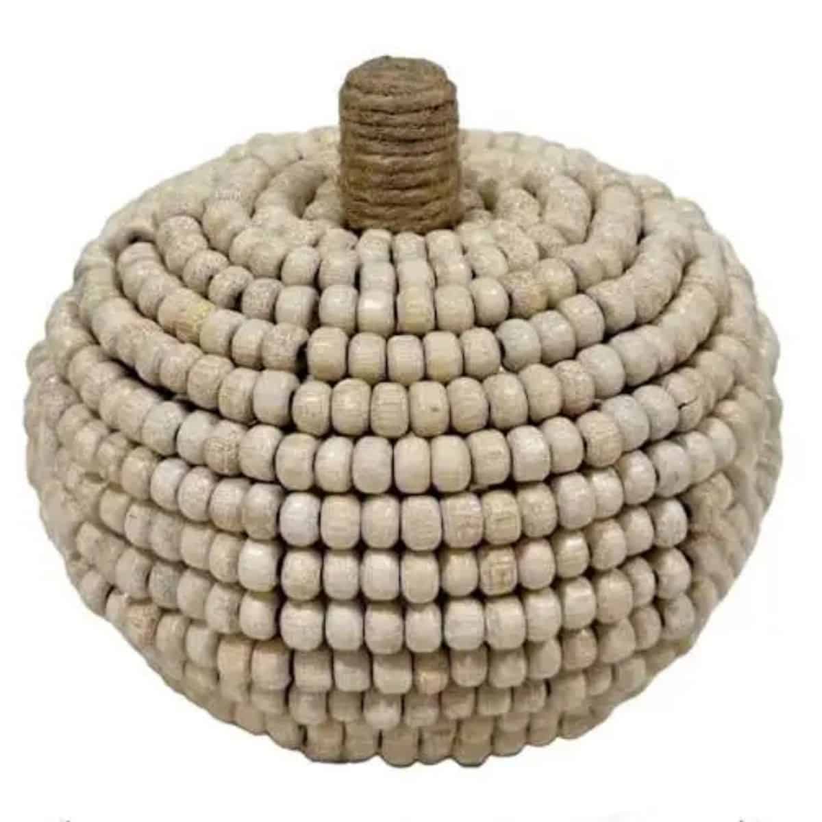 Neutral decorative pumpkin made from rows of cream wooden beads with a twine-wrapped stem on top.