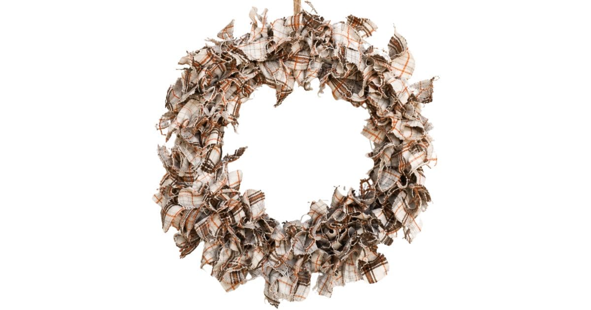 Finished DIY fabric wreath made with plaid fabric strips tied to a wire wreath form, creating a rustic fall door decoration.