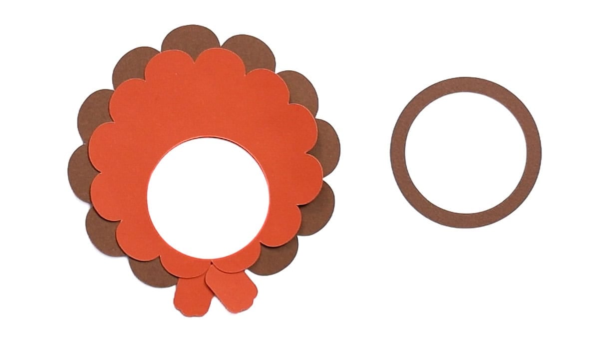 Layered brown and orange cardstock turkey feathers and feet assembled with a separate brown cardstock ring ready to attach.