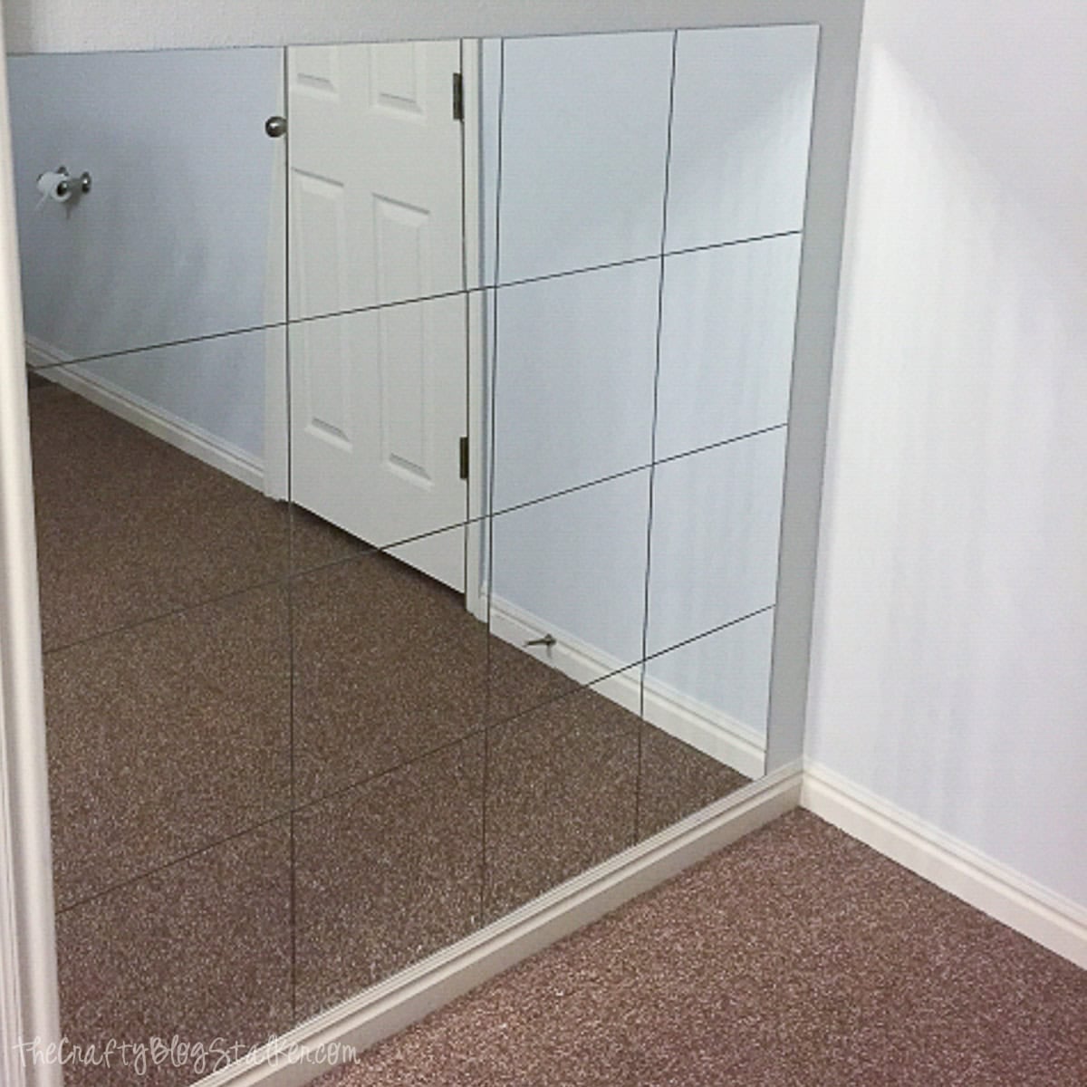Large mirror wall with grid pattern in a home interior.