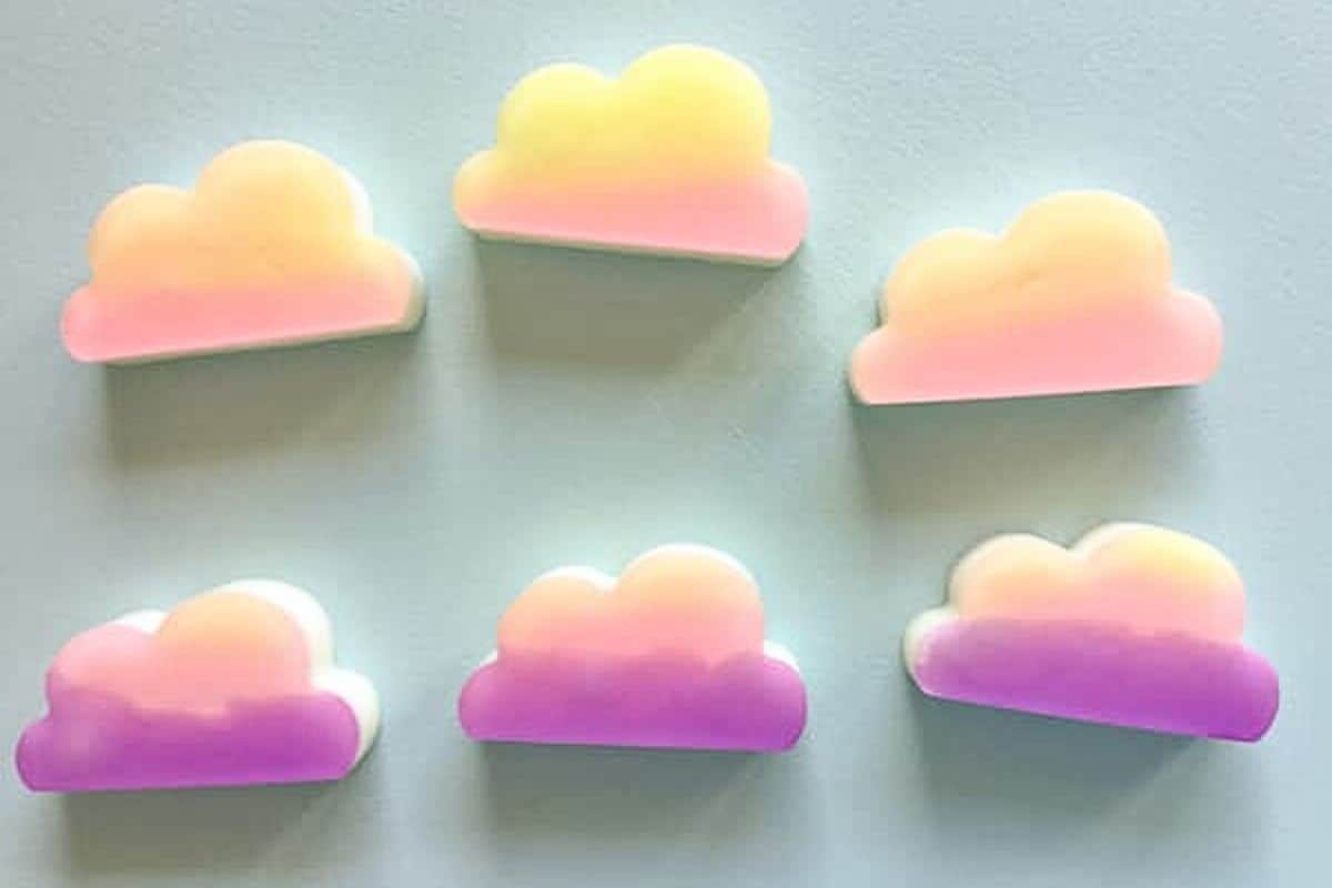 Cloud shaped bars of soap that are ombre in color from yellow to purple.