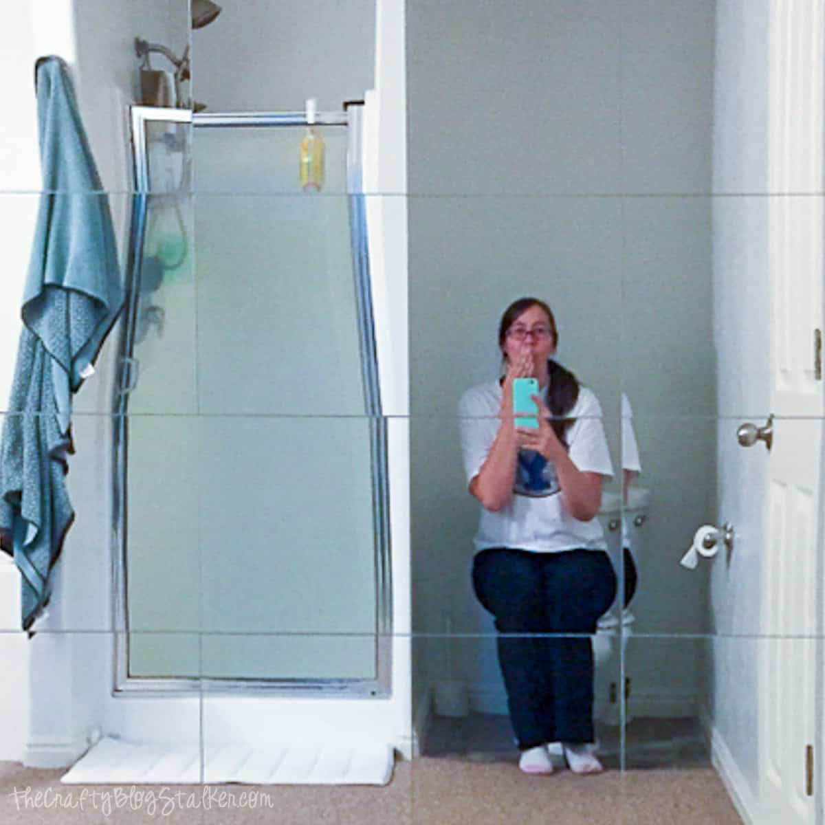 Decorative mirror wall with a person taking a selfie in a bathroom.