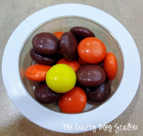 Reeses Pieces in a plastic treat cup.