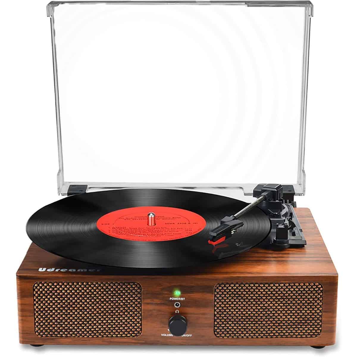 Wooden vinyl record player with built-in speakers, a clear dust cover, and a black record spinning with a red label on a white background.