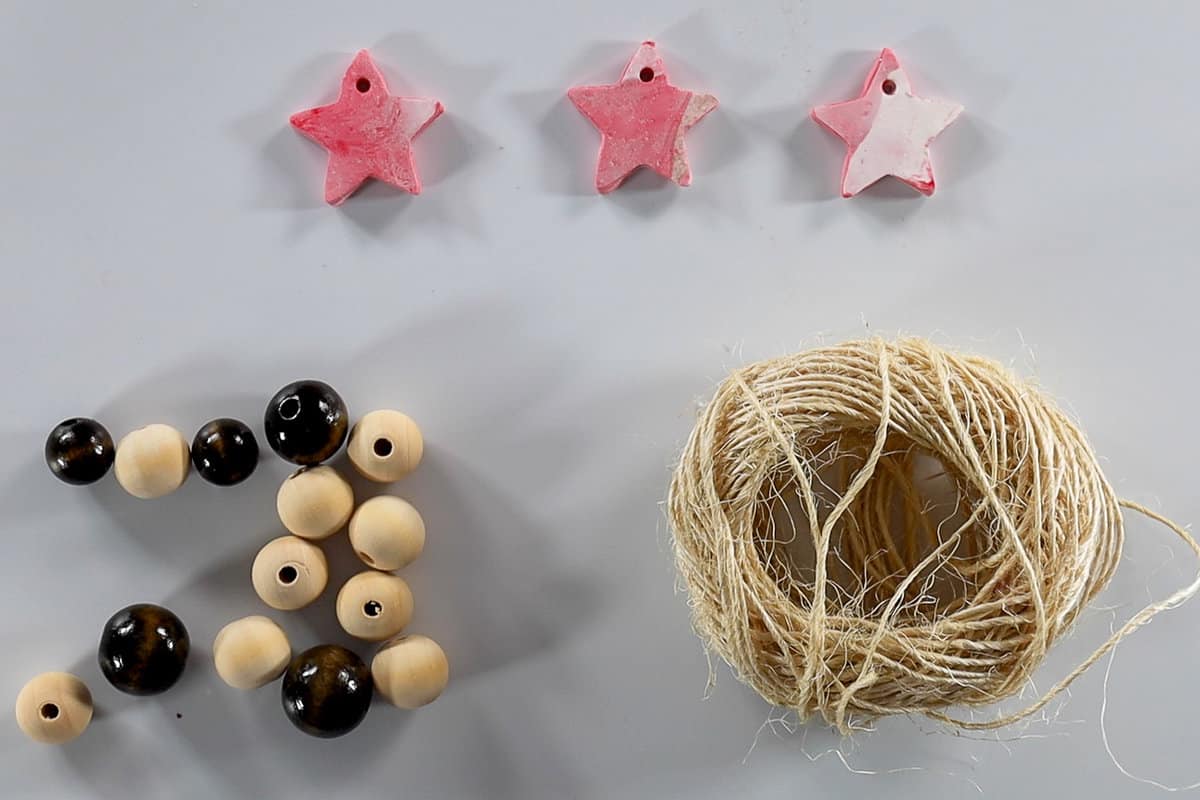 twine, beads, and clay stars to make the Christmas ornament