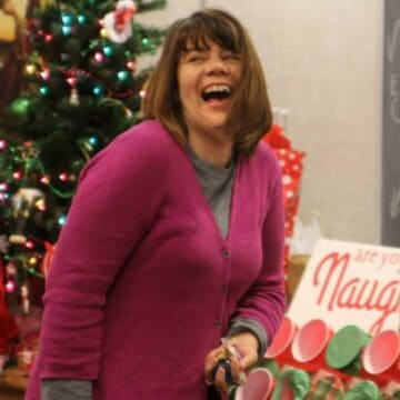 A woman laughing while playing the naughty or nice christmas game.