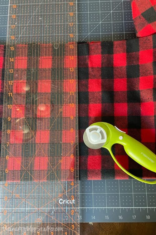 lining up the quilting ruler with the inch lines on the cutting mat