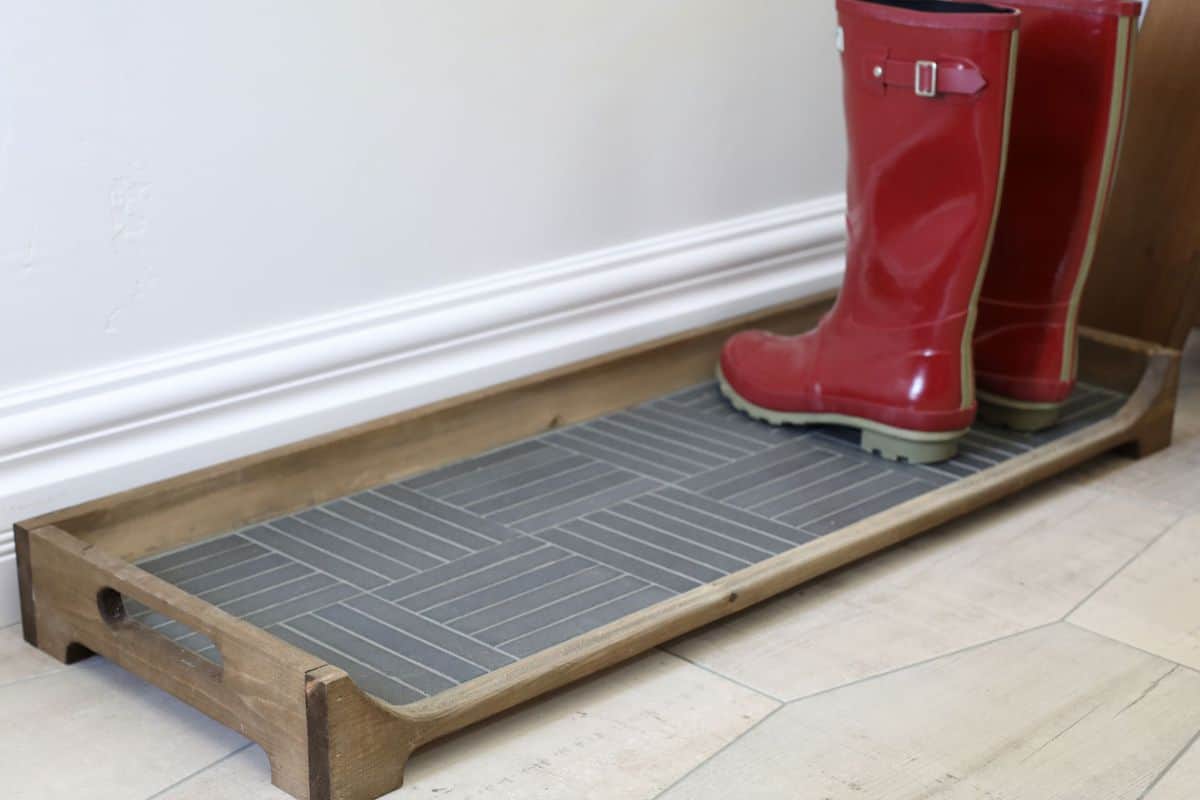 Tile Boot Tray holding red  galoshes.