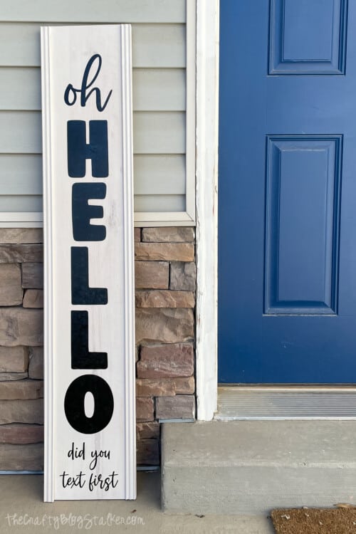 oh hello porch sign next to a blue front door