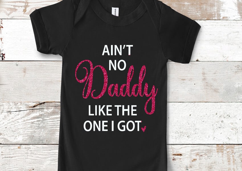 A black onesie with a design that reads "Ain't no daddy like the one I got".