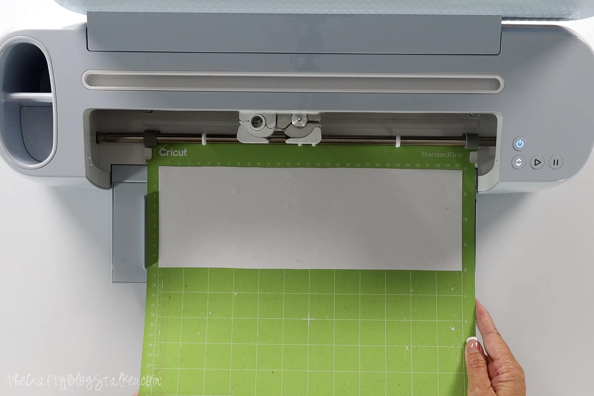 loading white vinyl on a Cricut mat into my Cricut cutting machine