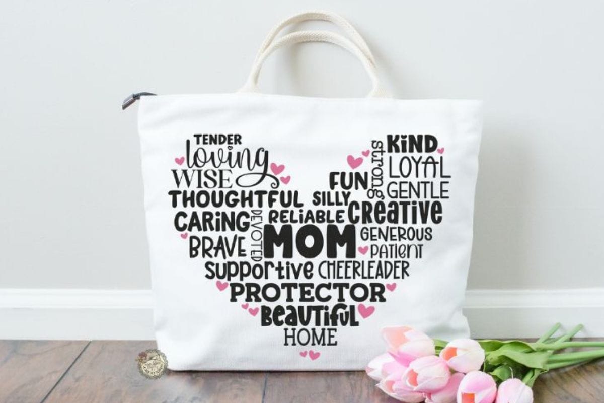 White tote bag with Mom word art in the shape of a heart.
