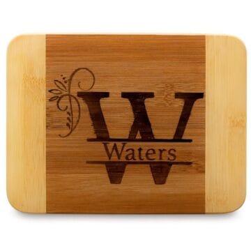 Bamboo cutting board engraved with a large letter W, decorative swirl design, and the personalized name Waters below.