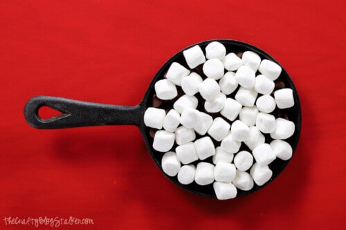 cast iron skillet with a layer of marshmallows