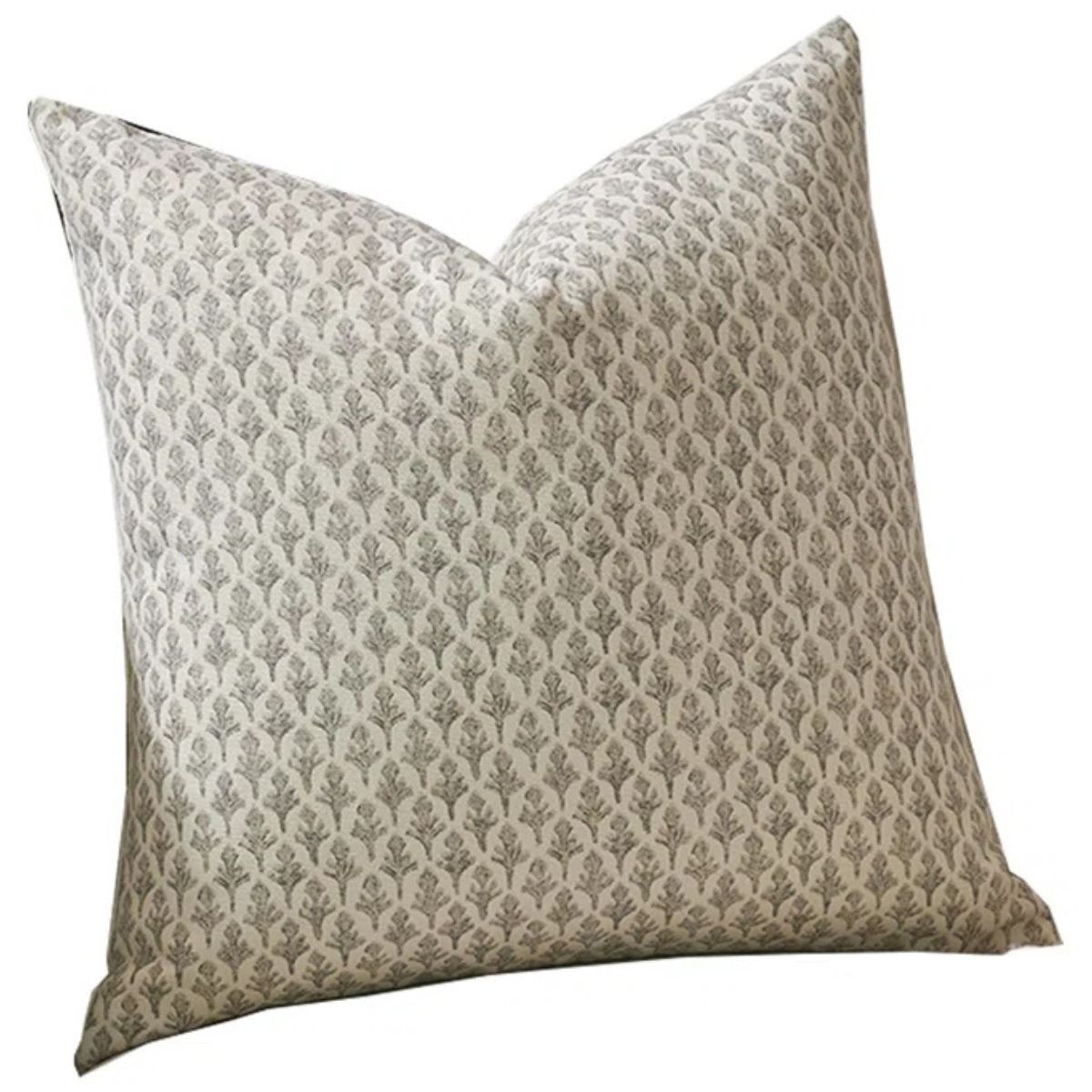 Cream throw pillow with a repeating gray block print floral pattern on a neutral background.