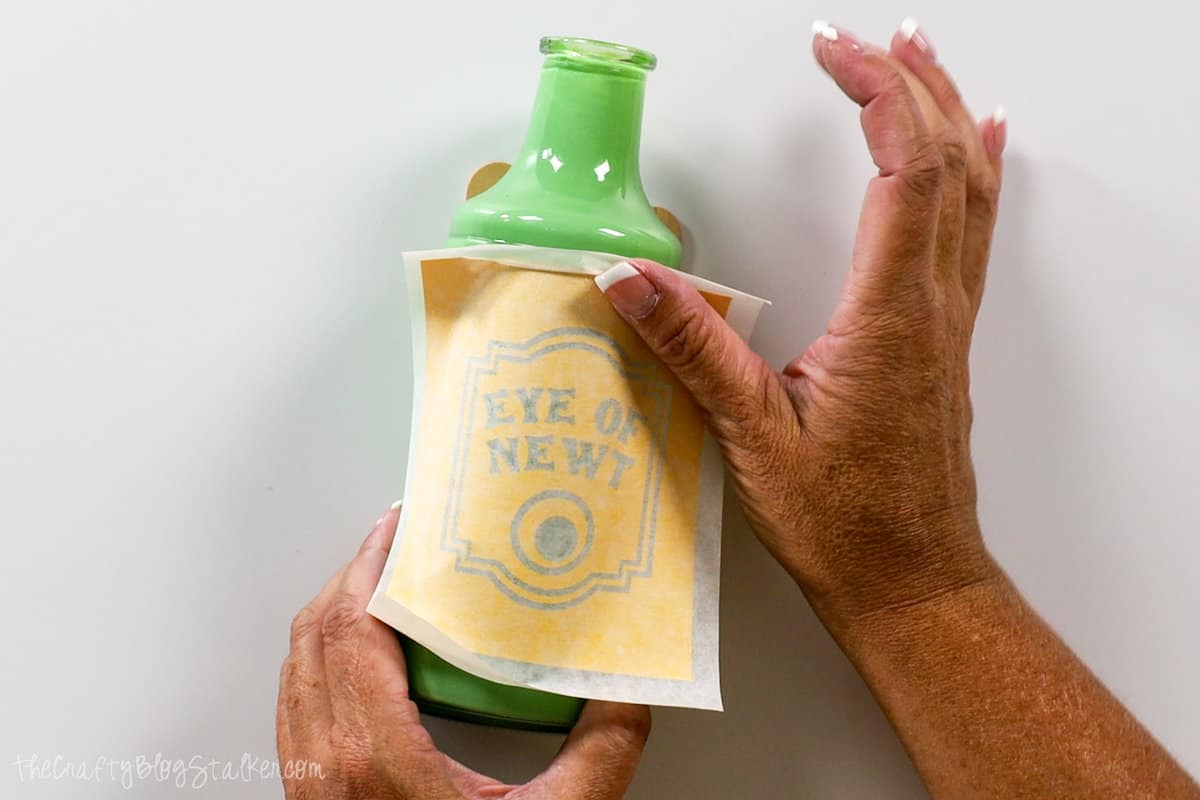 pressing the stencil onto the glass bottle
