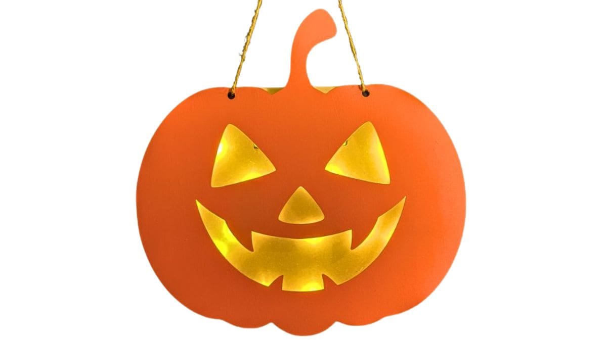 Light up pumpkin hanging on a blue door