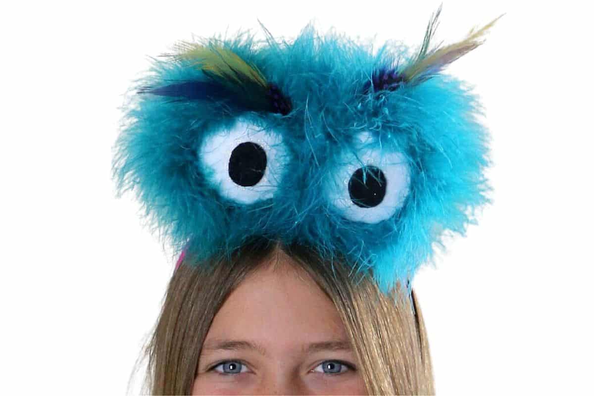 A girl wearing fluffly monster eyes headband.