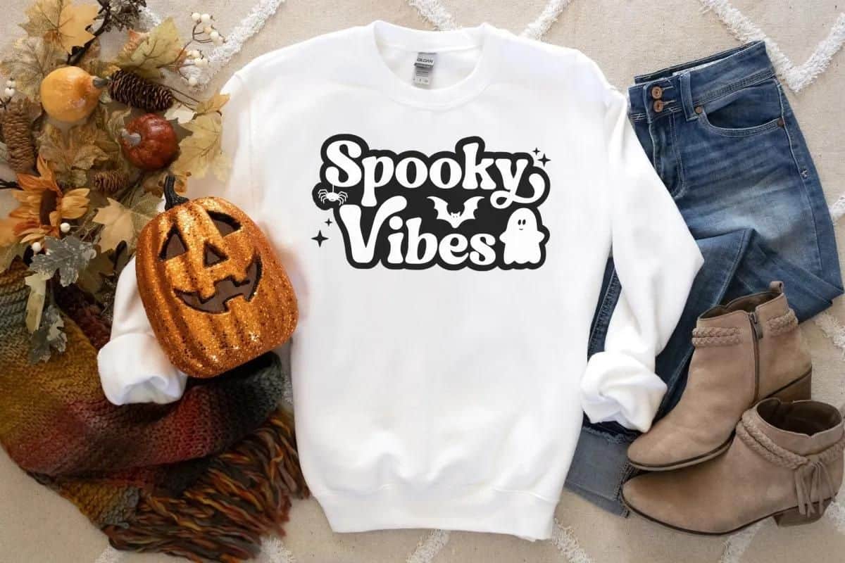White hoody with a design that reads 'spooky vibes'.