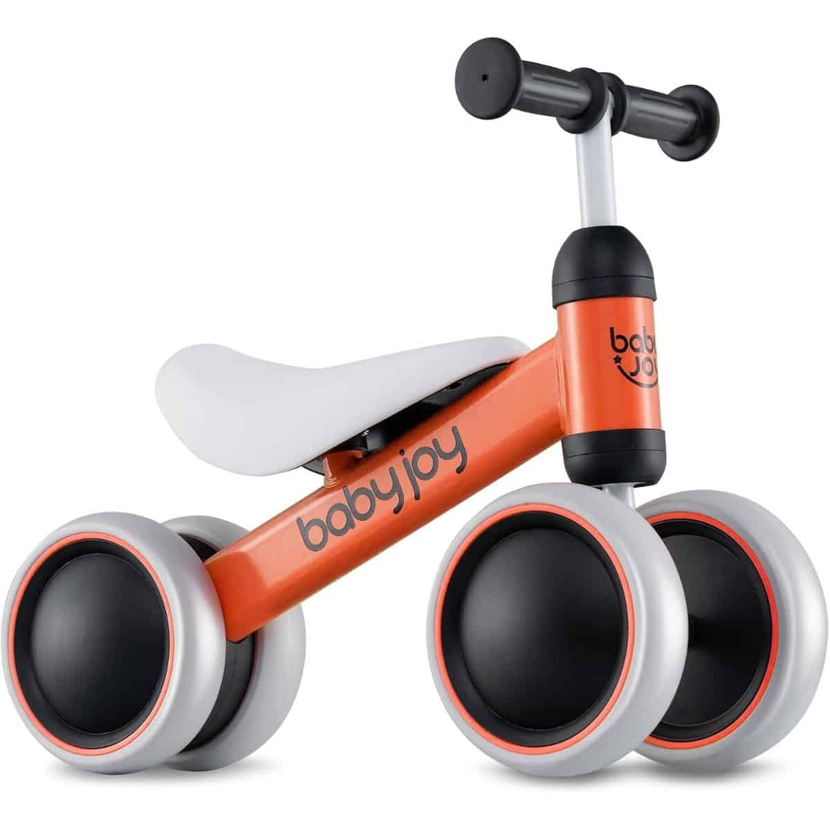 Orange Baby Joy balance bike with four gray wheels, a white seat, and black handlebars against a white background.