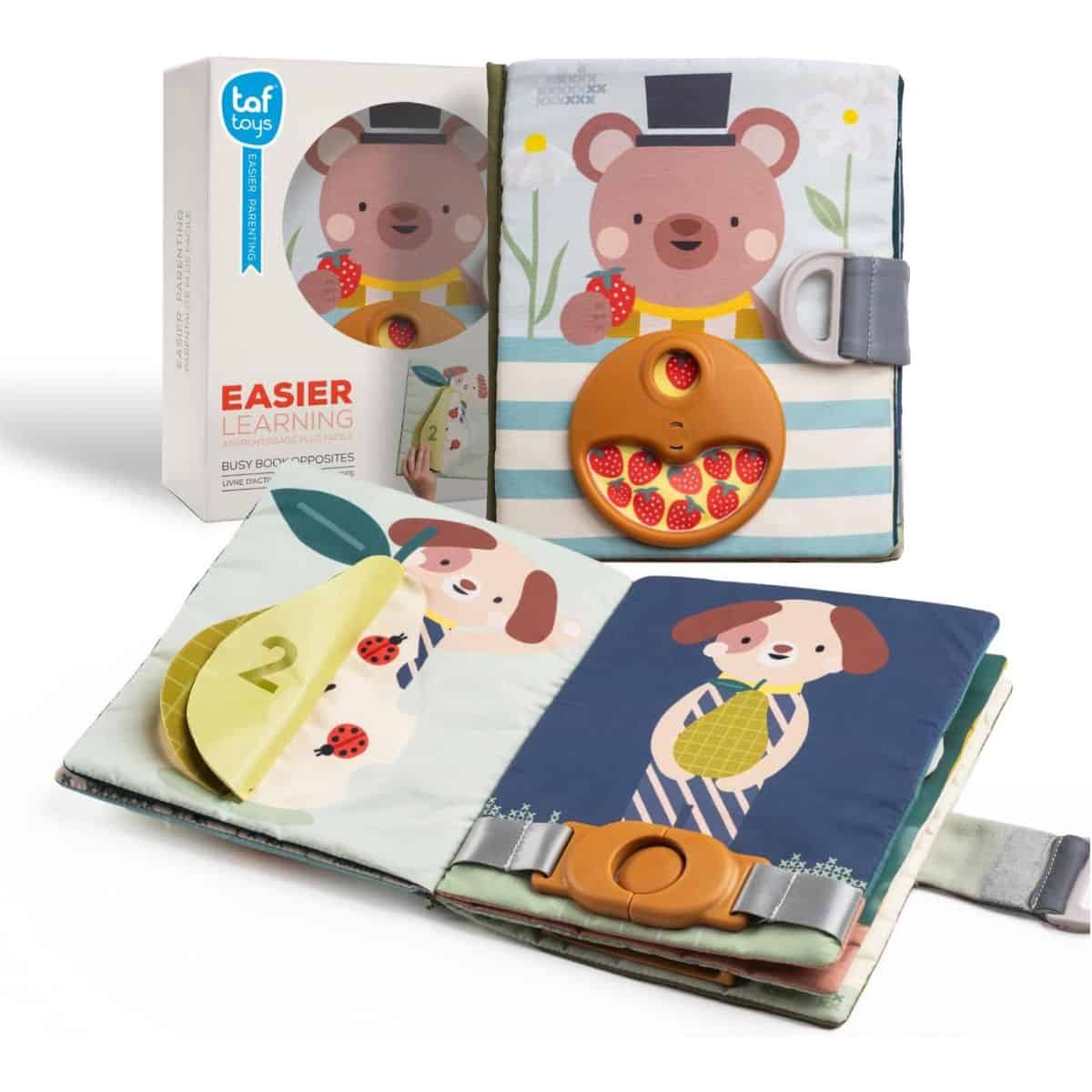 Soft fabric busy book for toddlers featuring colorful animal pages, lift-the-flap activities, buckles, and a spinning strawberry wheel, shown with its packaging.